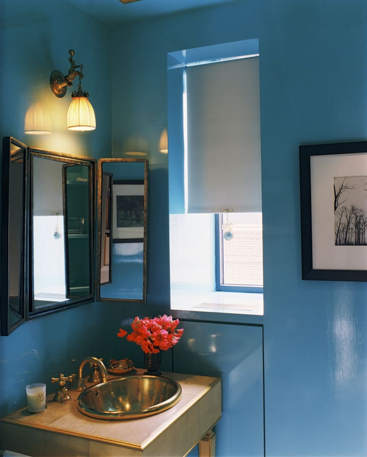 Bathroom with lacquered blue walls and brass sink