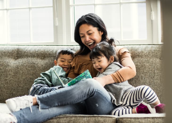 Mother reading to kids on couch