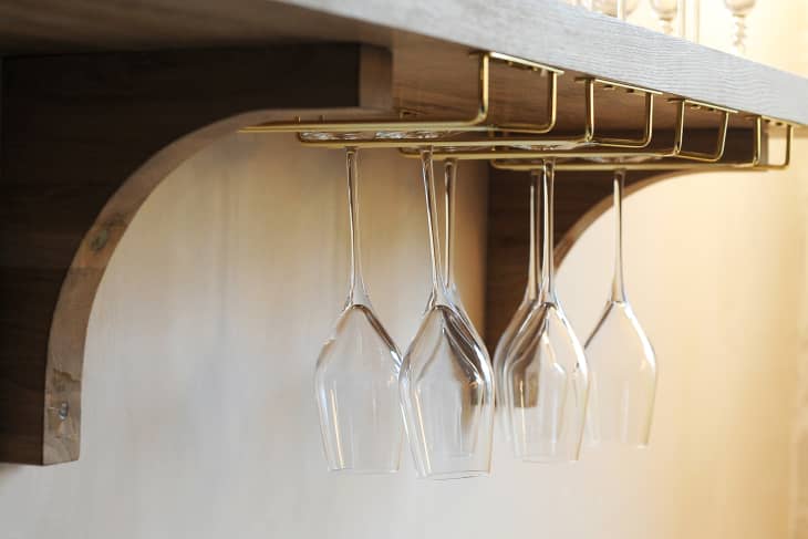 gold wine glass rack hanging under shelf