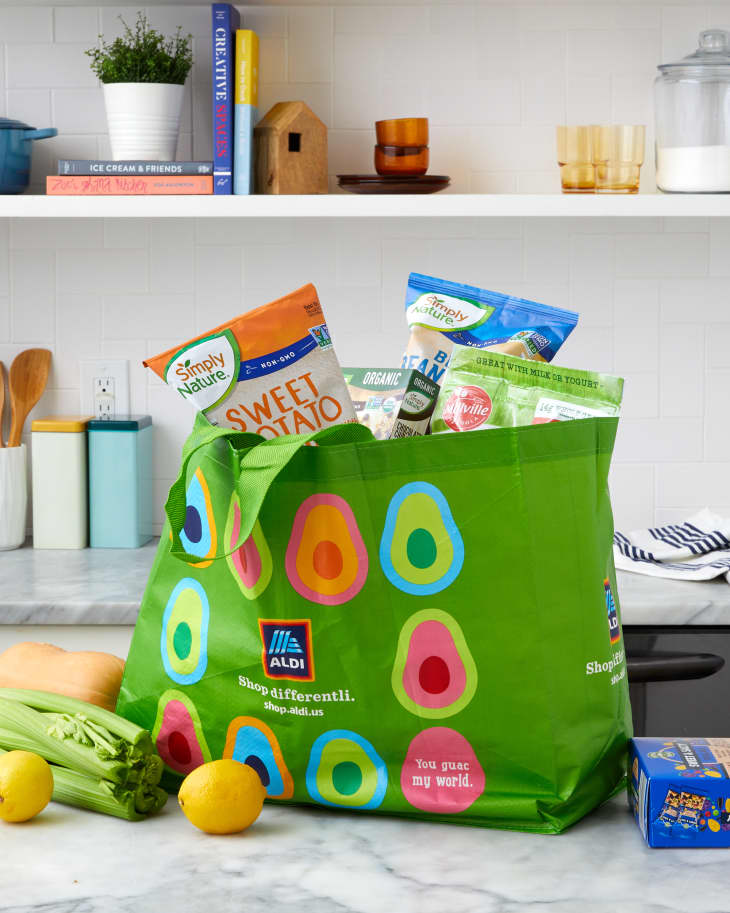 someone taking Aldi groceries out of an aldi bag in a kitchen setting
