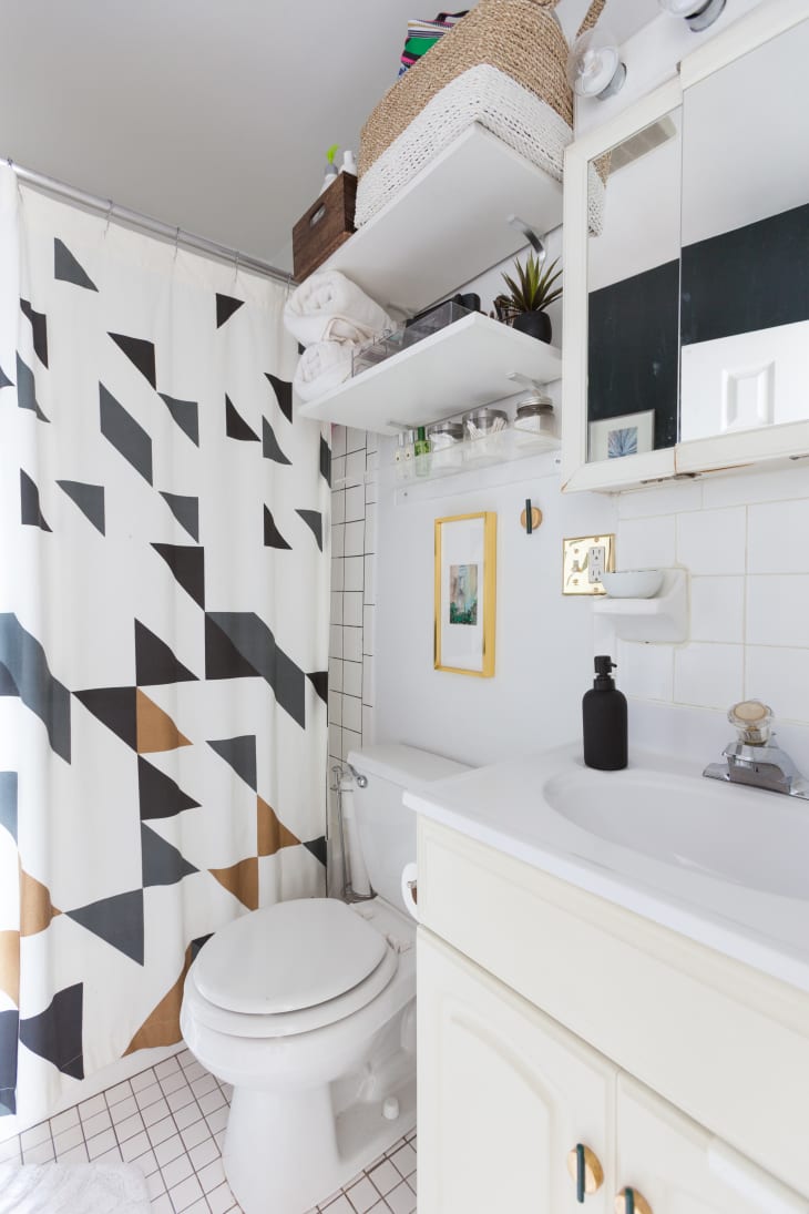 A white bathroom with a curtain featuring a triangular pattern