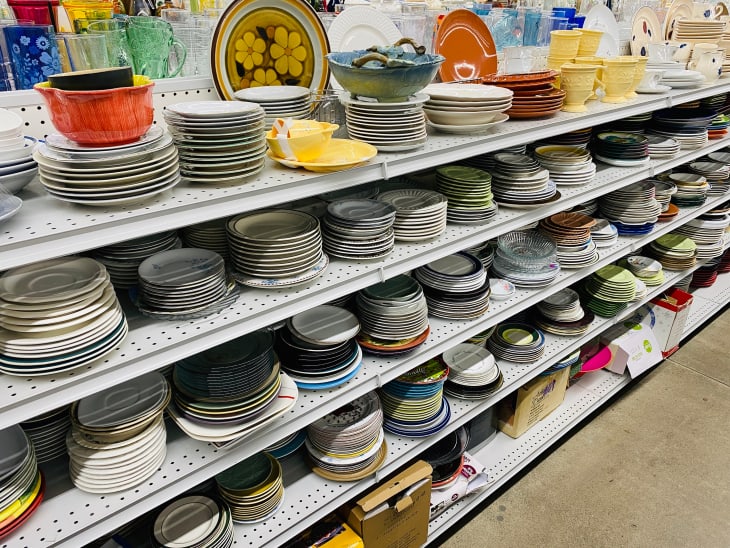 San Jose, CA - February 21, 2020: Variety of used plates and bowl on shelves inside a Goodwill store.
