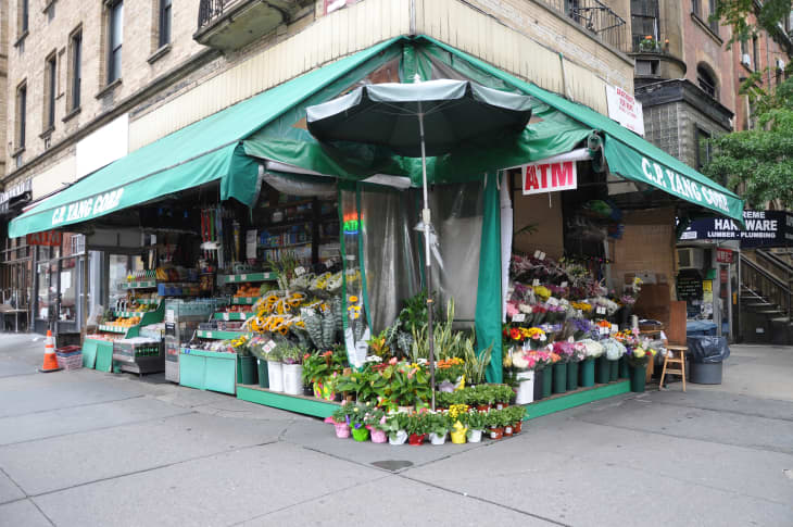 MANHATTAN, NEW YORK, USA - JULY 3, 2013: Local corner market on the upper west side on Columbus Ave in Manhattan New York City that sells flowers, fruit, grocery items and has 24hr ATM machine.