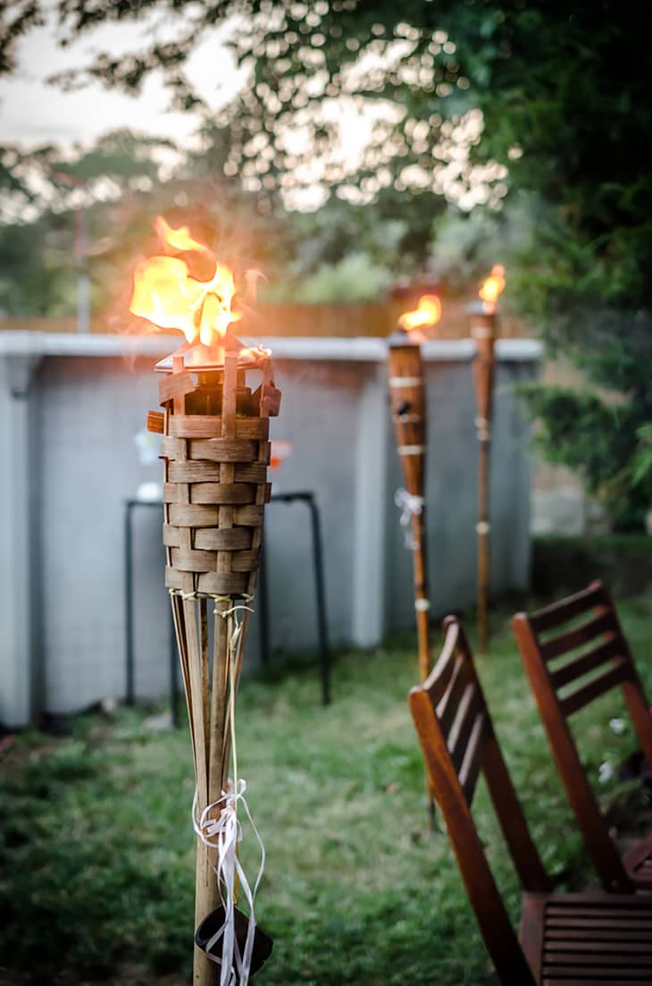 A lit tiki torch in the yard