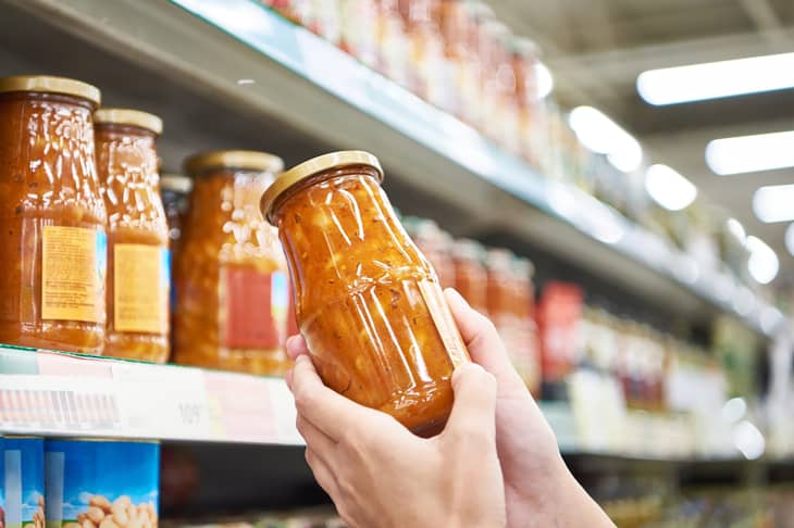 Jar of beans with vegetables in the hands of a customer in a store