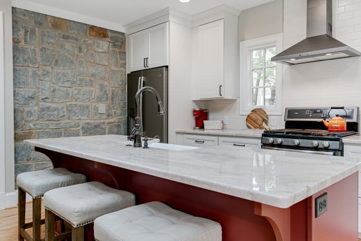 Luxury Spring Modern Kitchen Interior with White Marble Countertops and Red Island and Oval Window