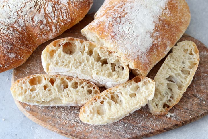 Sliced, freshly baked ciabatta reveals its airy interior, showcasing the mastery of Italian baking. Crusty edges paired with soft sections, ready for toppings or dips