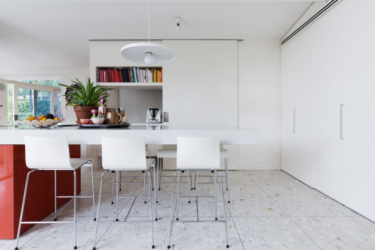 white modern kitchen island bench with high chairs and terrazzo floor