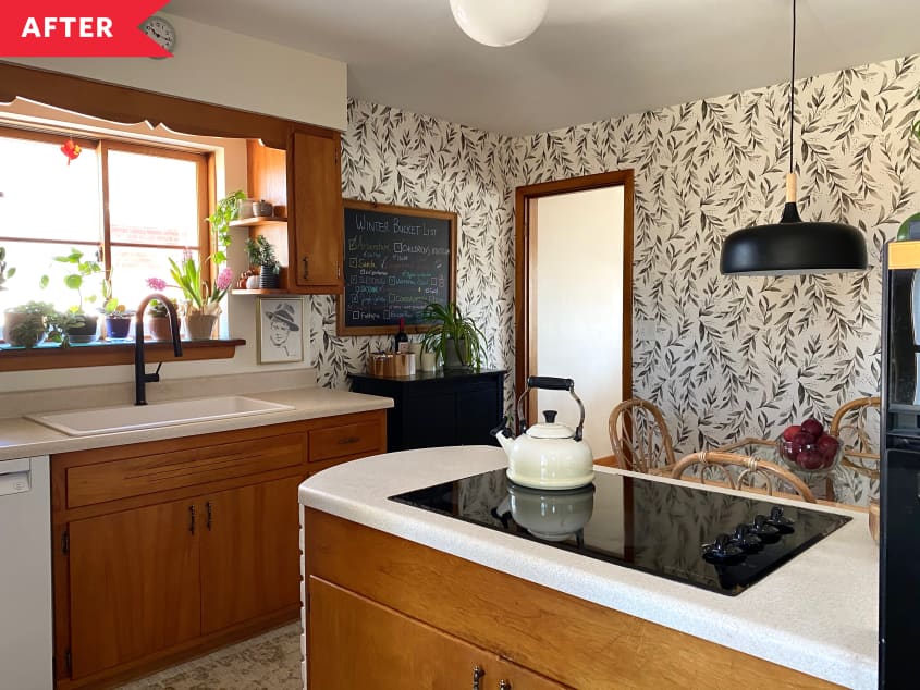 After: Wallpapered kitchen with white counters, wood cabinets, and a white sink with black faucet