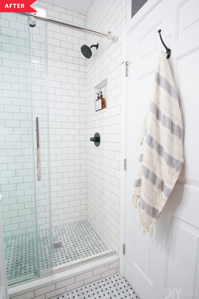 After: A white tiled walk-in shower with glass door
