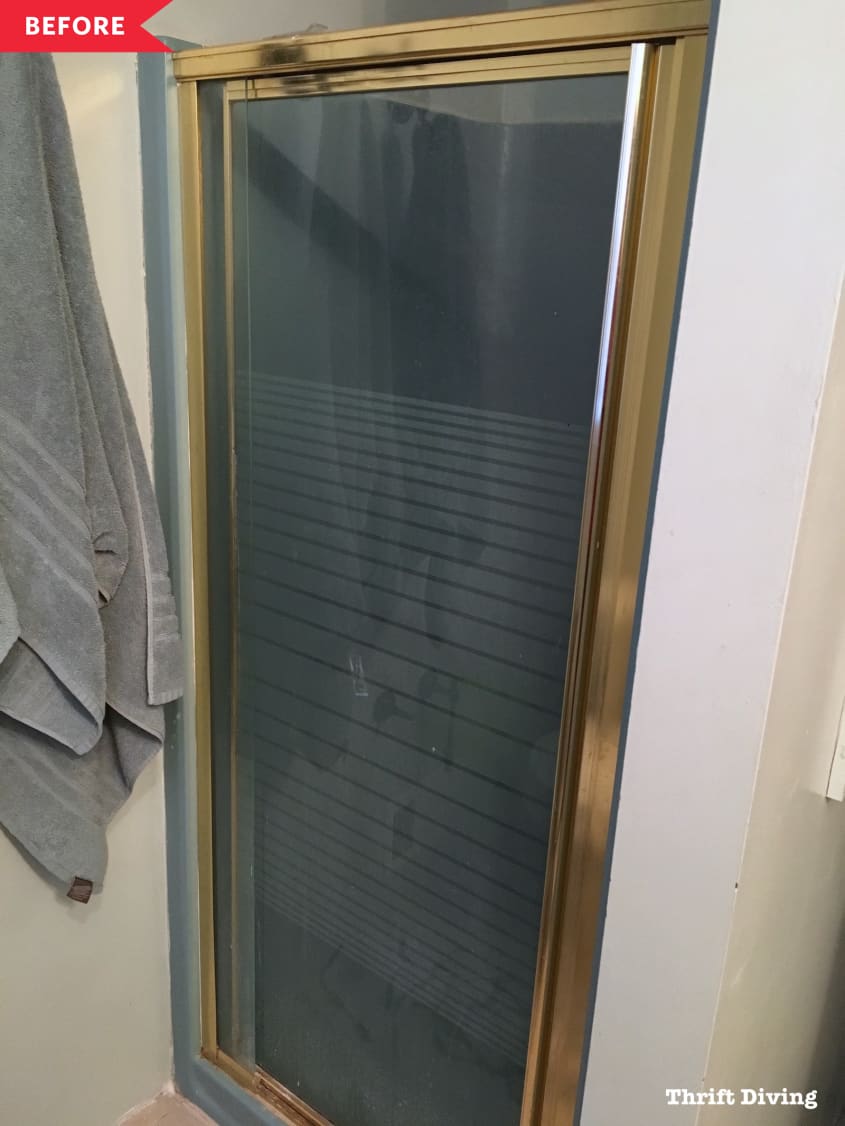 Before: Small glass shower with brass accents