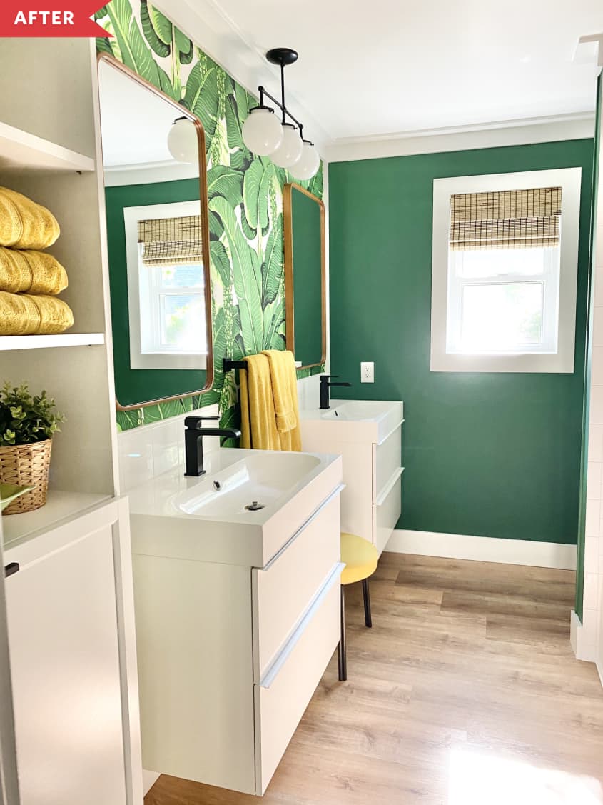 After: Bathroom with bright green wall and leaf-wallpapered wall, with white floating vanities