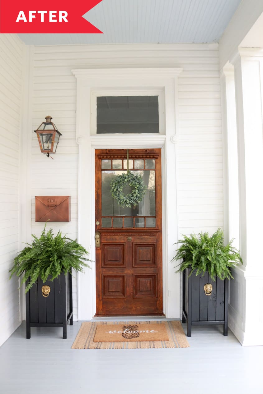 After: Wooden front door styled with wreath and planters on either side