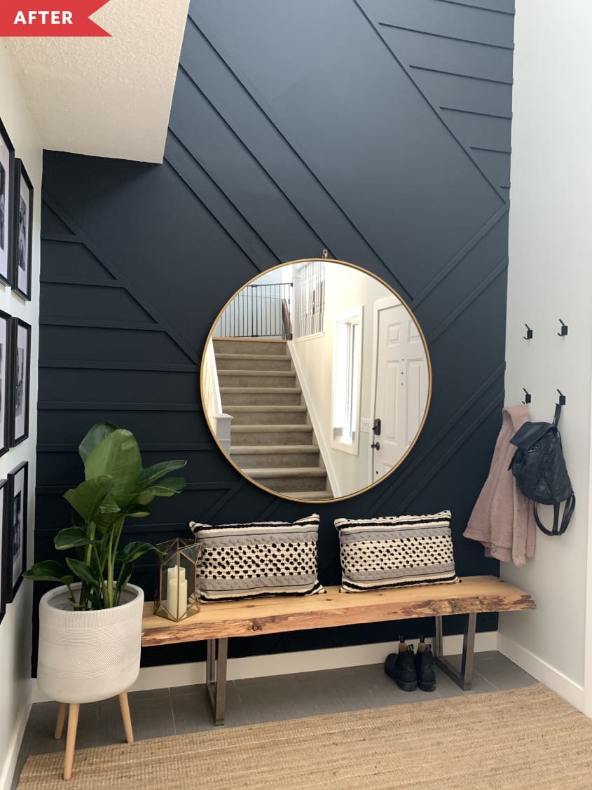 After: Entryway with geometric black wall, bench, potted plant, and mirror