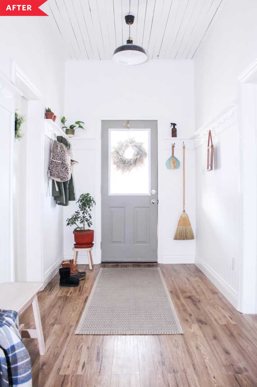 After: White entryway with laminate floors and hooks for coats