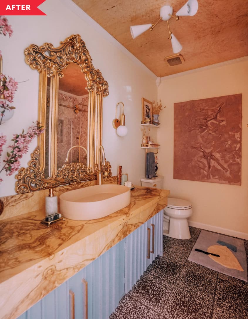 After: Bathroom with blue vanity with wood countertop, patterned tile floor, and pinkish ceiling