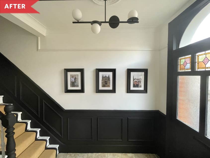 After: Entryway with stained glass on front door, three framed photos on wall, and black wainscoting
