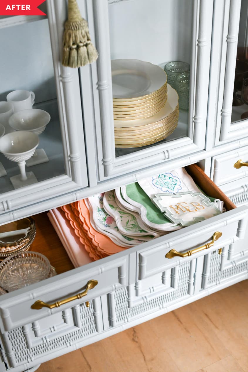 Drawer of china cabinet open to show folded linens inside