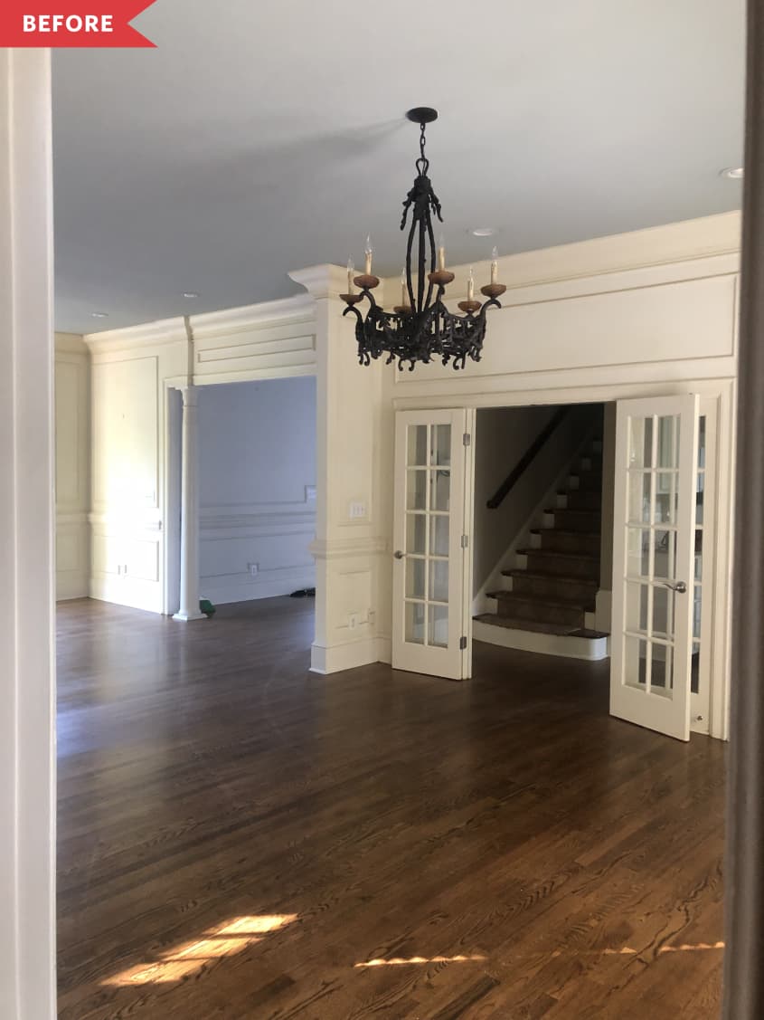 Before: Traditional dining room with brown wood floors and white walls, plus a black chandelier