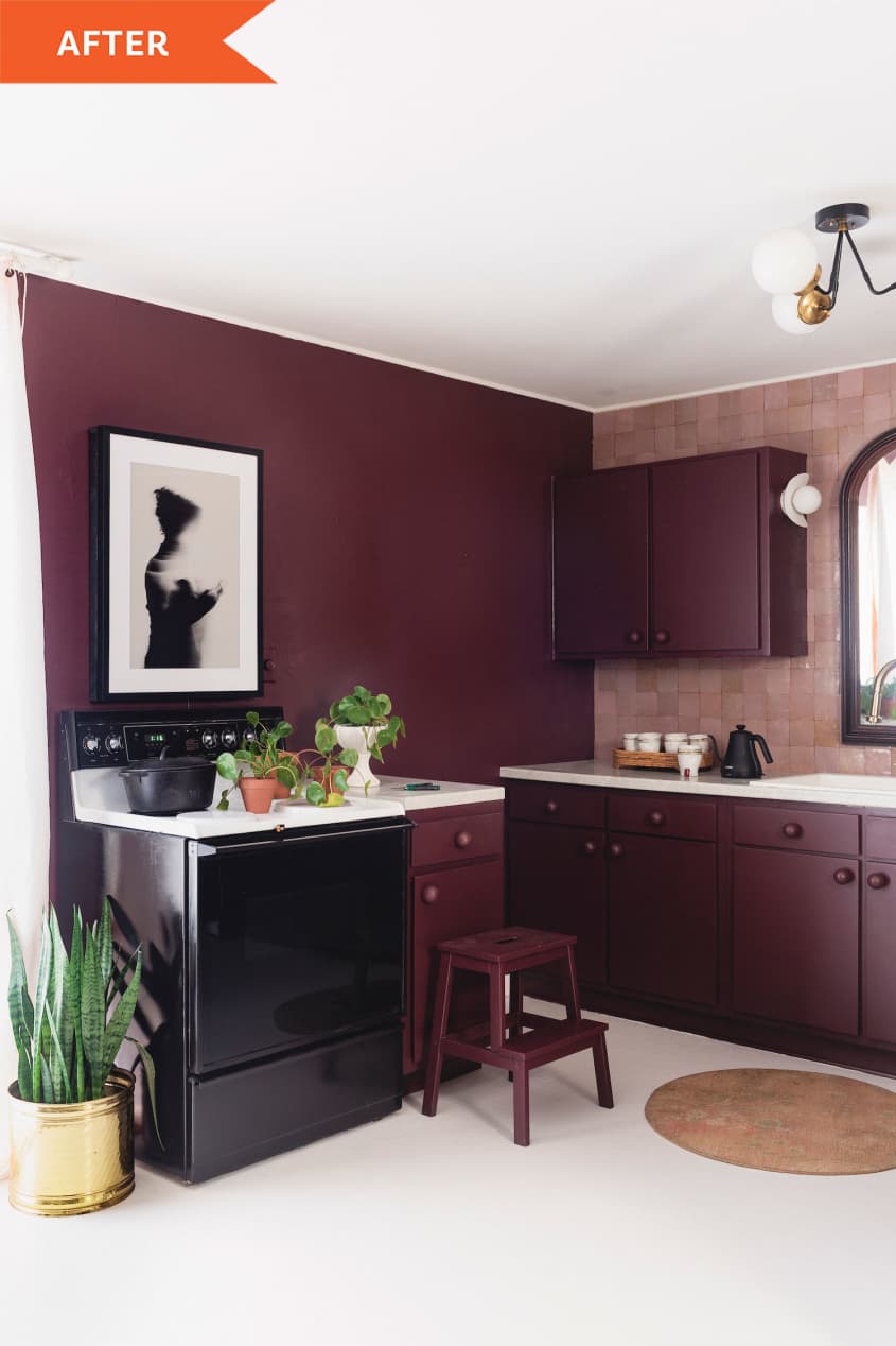 Corner of the kitchen with art on merlot walls and black oven
