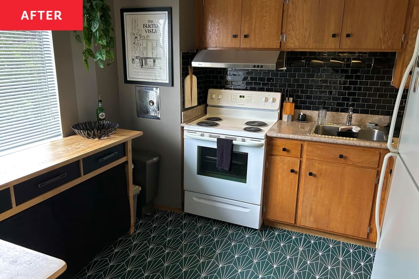 Kitchen with green graphic tiles and black backsplash behind stove after renovation.