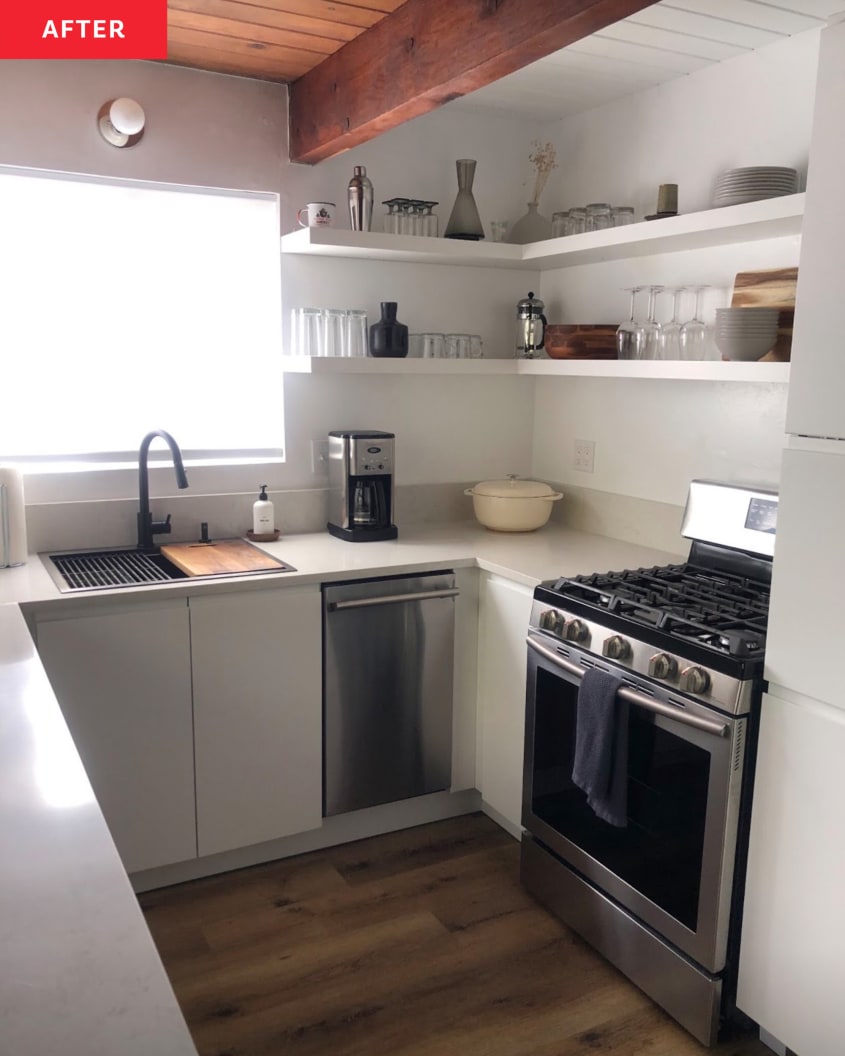 A-frame kitchen after renovation: white cabinets, white walls, open white shelves, pale gray countertops