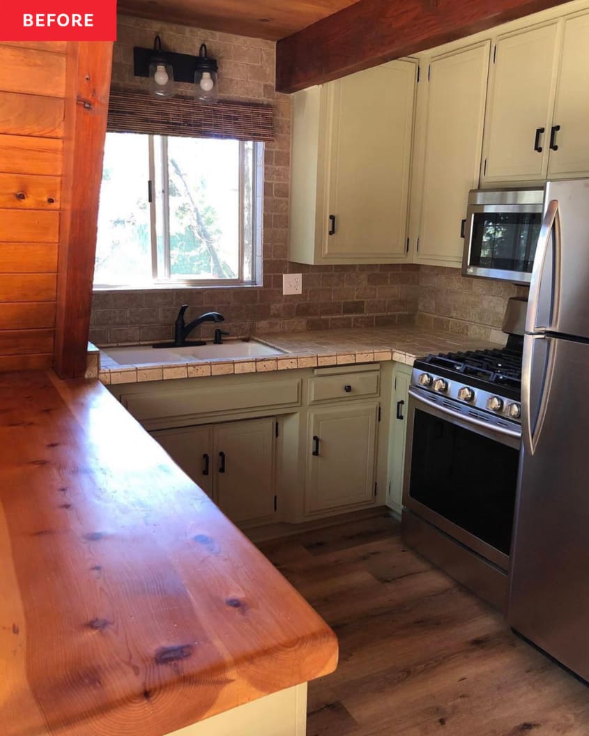 A-frame kitchen before renovation: pale green cabinets with black pulls, brown tile countertops and backsplash/wall, one wood counter.