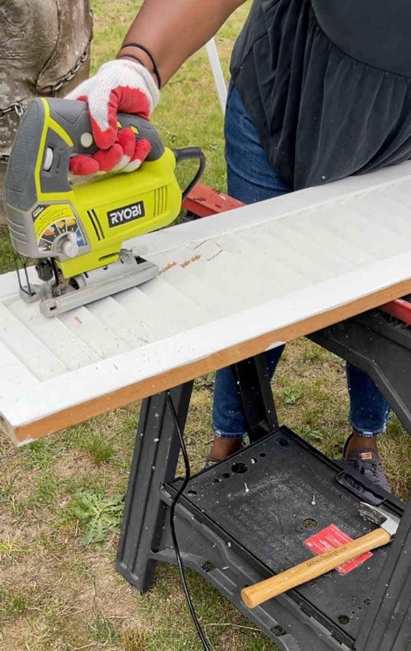 Using a jig saw to cut the louvers out from the center of closet door