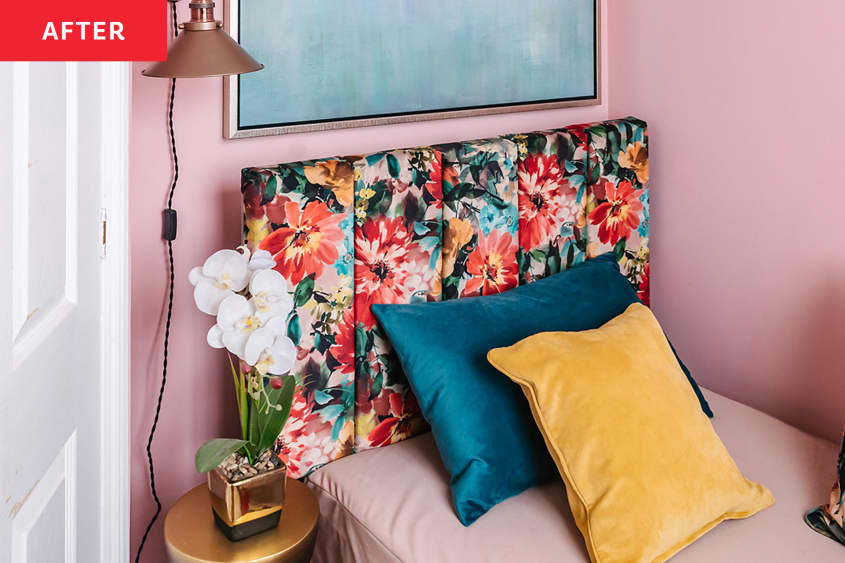 Small gold task lamp hung on wall beside floral upholstered bed with colorful decorative pillows.