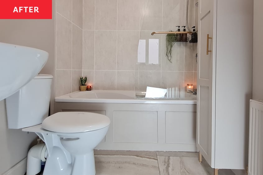 A renovated bathroom with candles and new storage cabinets.