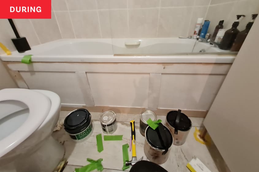 A bathroom going through renovation with paints and other tools.