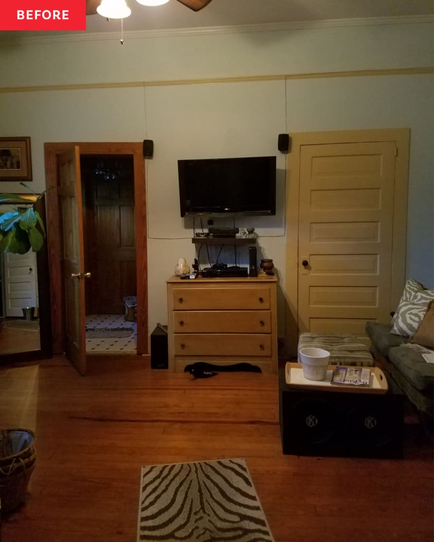 A bedroom with wooden doors, tv above a large wooden dresser, and wooden floors.