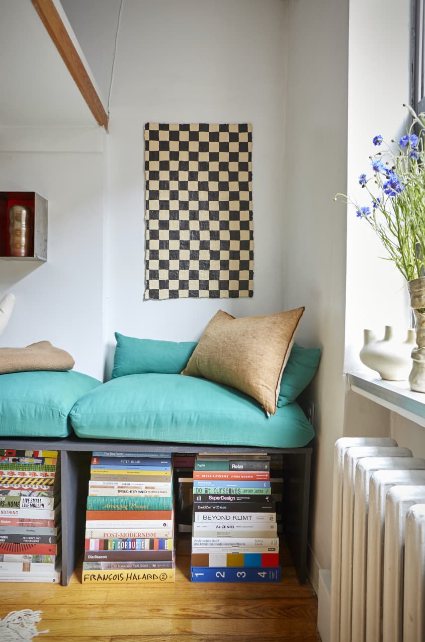 DIY沙发凳，上面有一堆艺术书籍，上面挂着一幅棋盘艺术作品