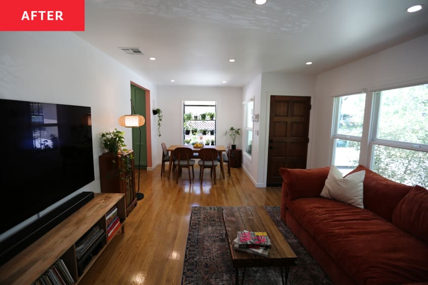 Rectangular dining table sits opposite living room. Rust colored sectional across from media center in living room.