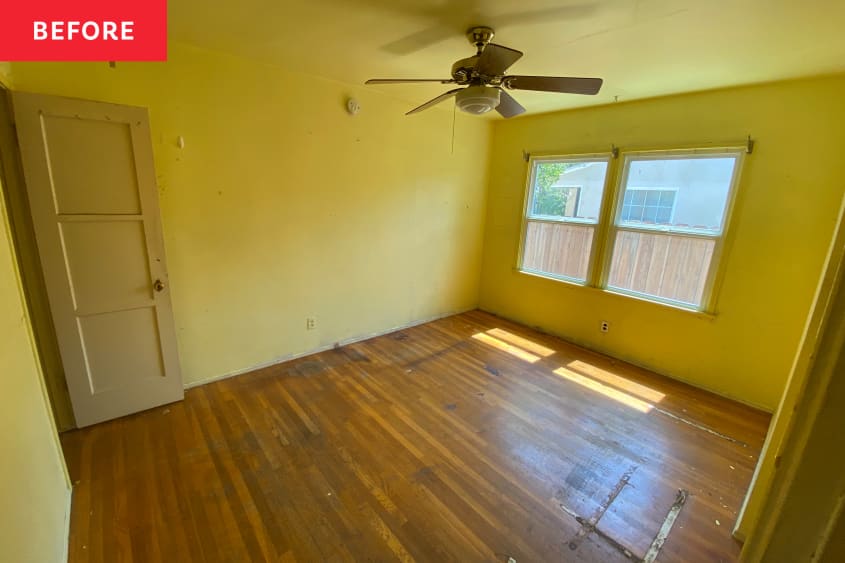 Bright yellow painted bedroom with ceiling fan and damaged wood floors.