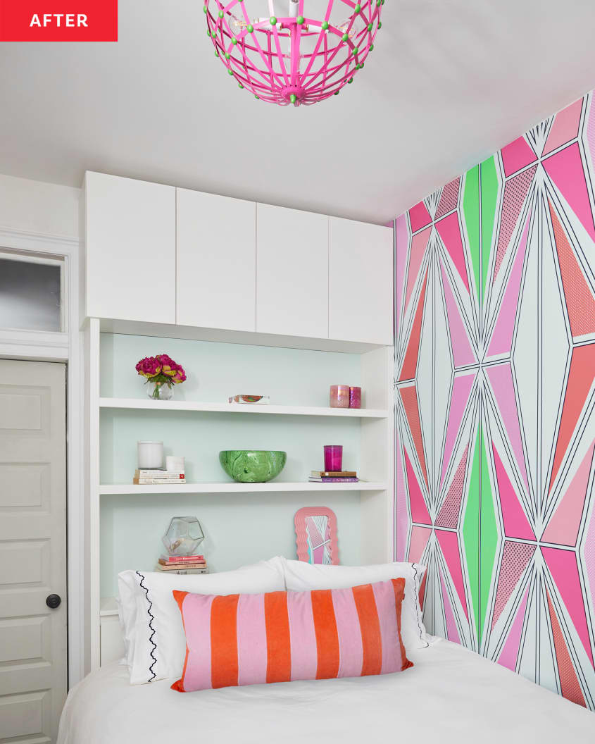 Colorful graphic wallpaper lined bedroom wall in newly renovated room with open shelves behind bed. Bed is neatly made with white sheets and a colorful decorative pillow.