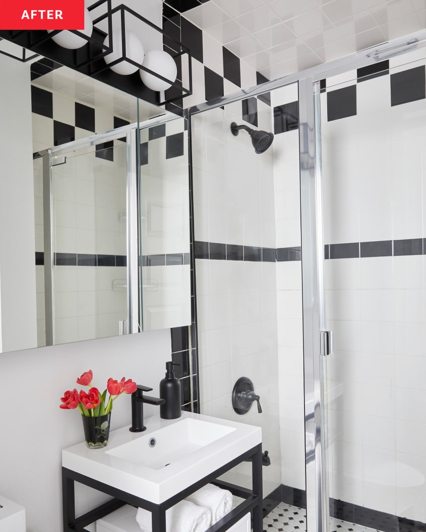 Black and white tiled bathroom with glass shower door and small black and white vanity.