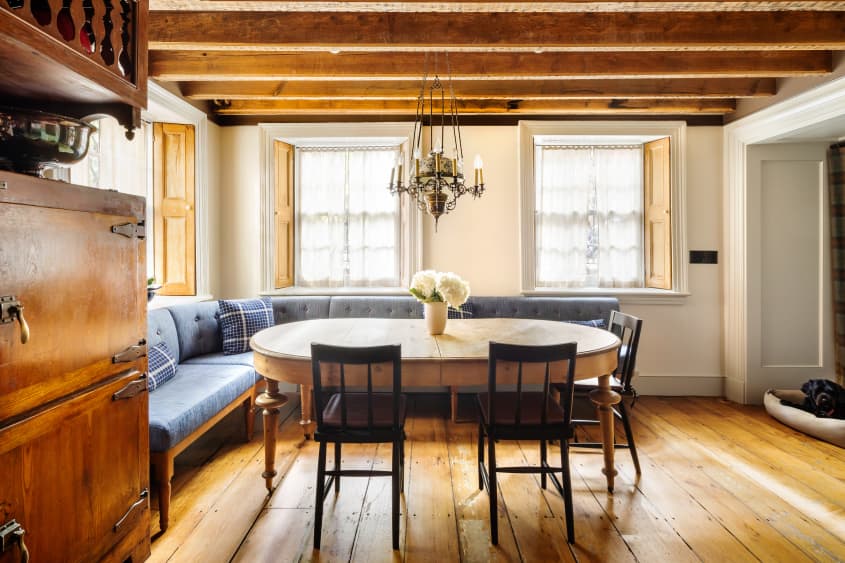 Dining area with cushioned  L-shaped bench and oval table in corner