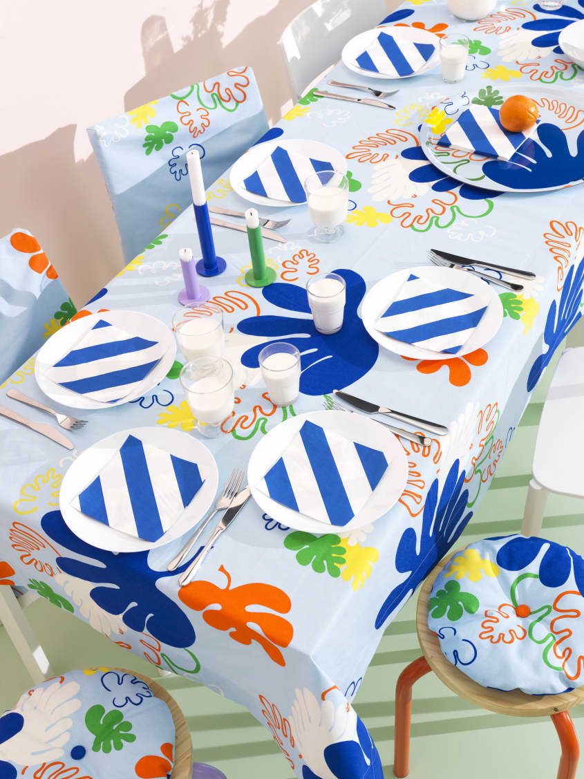 Colorful studio photo of items from the IKEA 80th anniversary Nytillverkad collection - table set with colorful tablecloth, dishware, candles