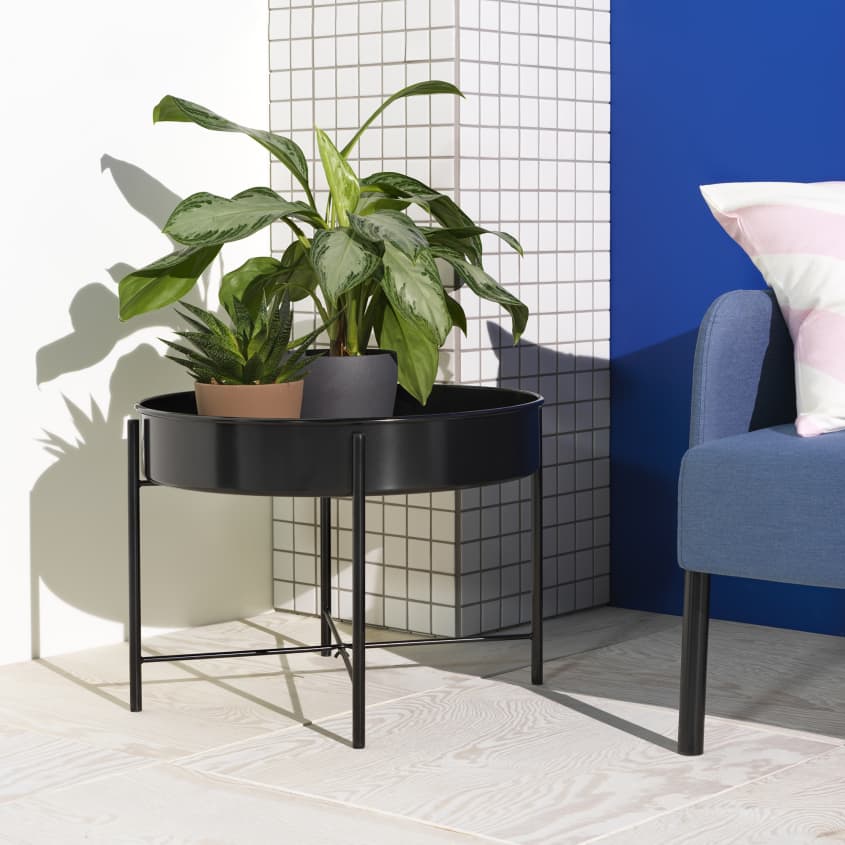 Colorful studio photo of items from the IKEA 80th anniversary Nytillverkad collection - black round side table