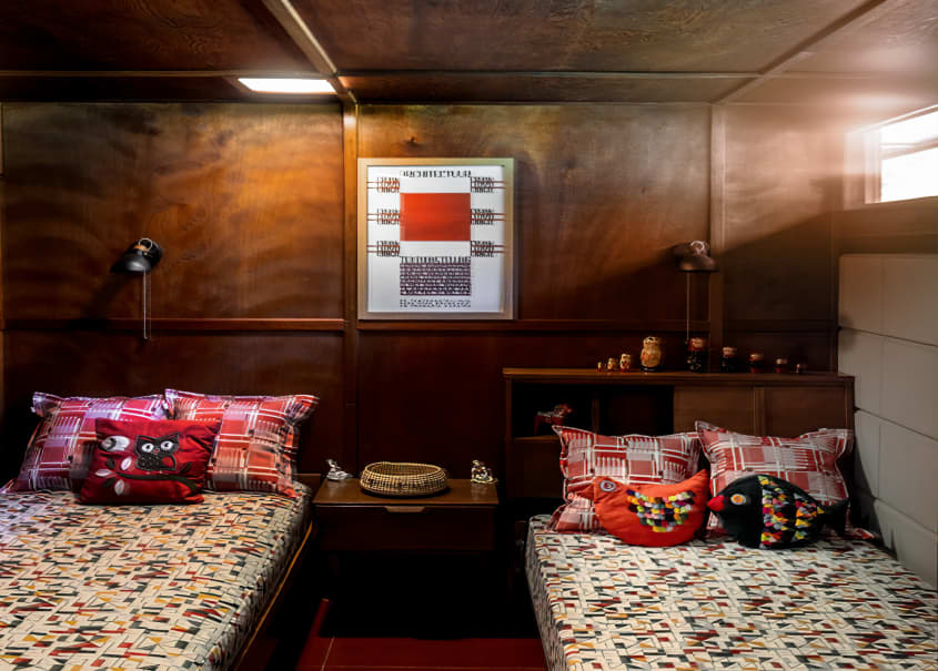twin beds in a wood paneled room with rectangle slit windows