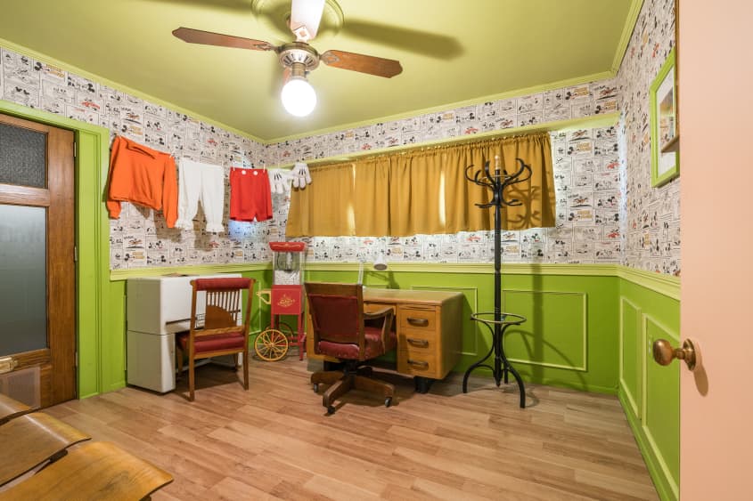 Multipurpose room with kitschy wallpaper and bright green wainscoted walls