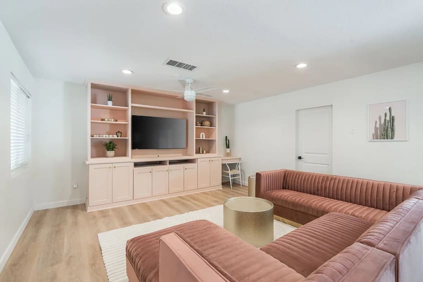 Pink living room with large sectional in bachelorette party house.