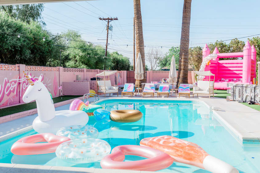 Backyard swimming pool filled with floaties at bachelorette party home.