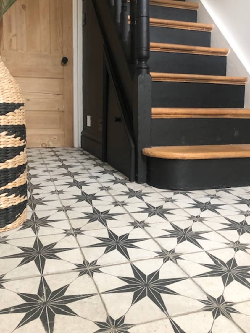 Black and white scintilla floor tile next to staircase