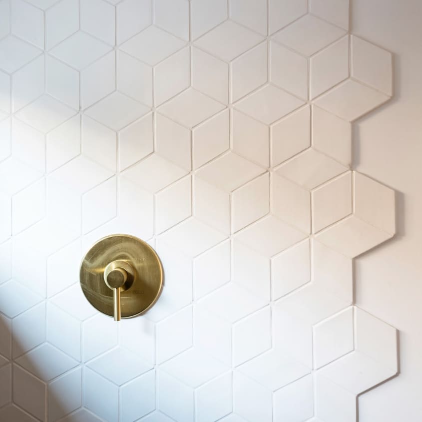White rhombus-shaped tile in tumbling block pattern in shower