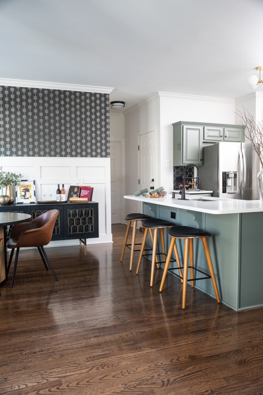 Connected dining area and Kitchen with sage green cabinetry and a matte black hexagonal backsplash and stainless steel appliances designed by Marie Cloud of Indigo Pruitt;