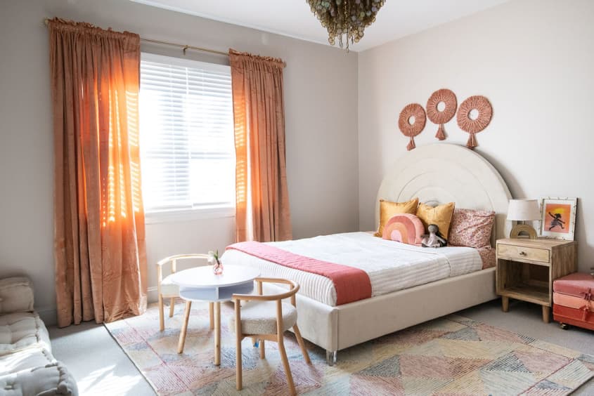 Kid's room designed by Marie Cloud of Indigo Pruitt with neutral furnishings and pops of coral and pink for contrast