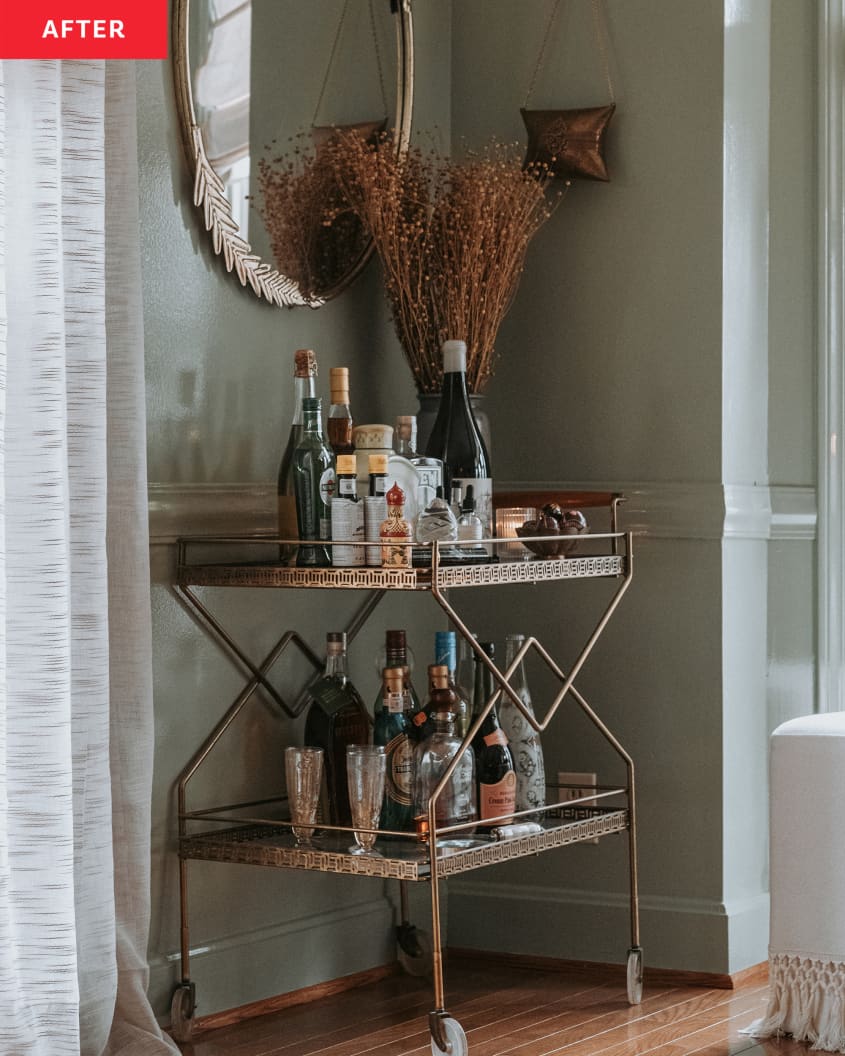 Photo after home office remodel: stocked bar cart with dried plant arrangement, oval mirror on wall above