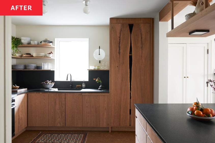 Kitchen with walnut colored cabinets, dark backsplash and cream colored walls after renovation.